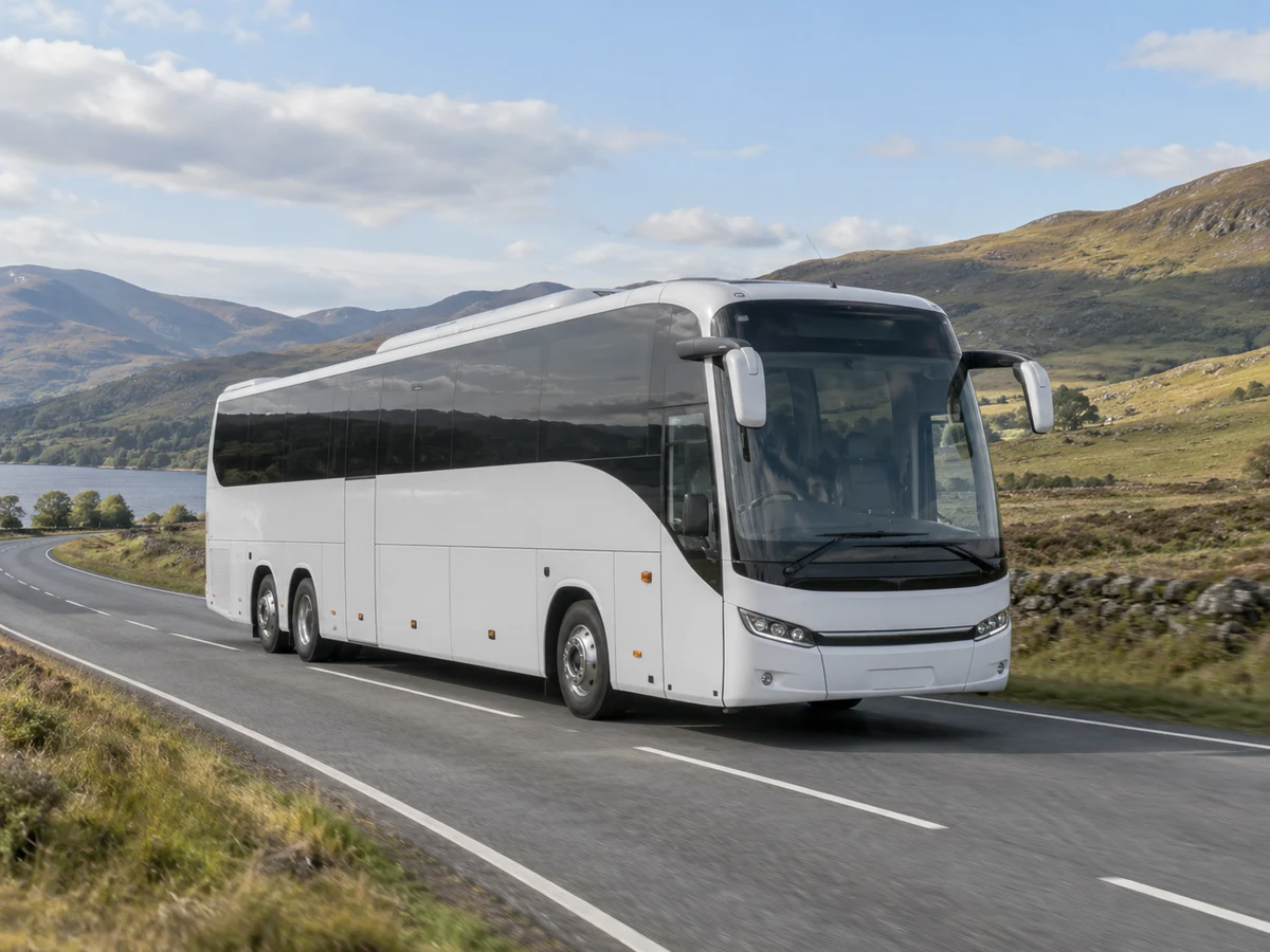 White intercity coach travelling on an open countryside route.